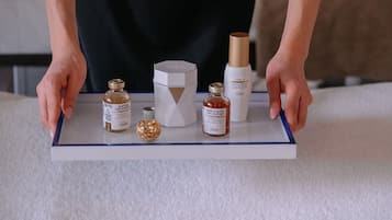 A person holding a tray with various skincare products.
