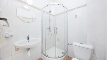 Un bagno con doccia vetrata, lavandino e water.