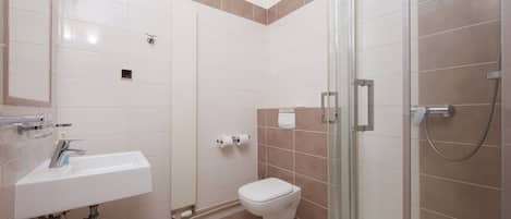 A modern bathroom with a sink, toilet, and glass-enclosed shower.