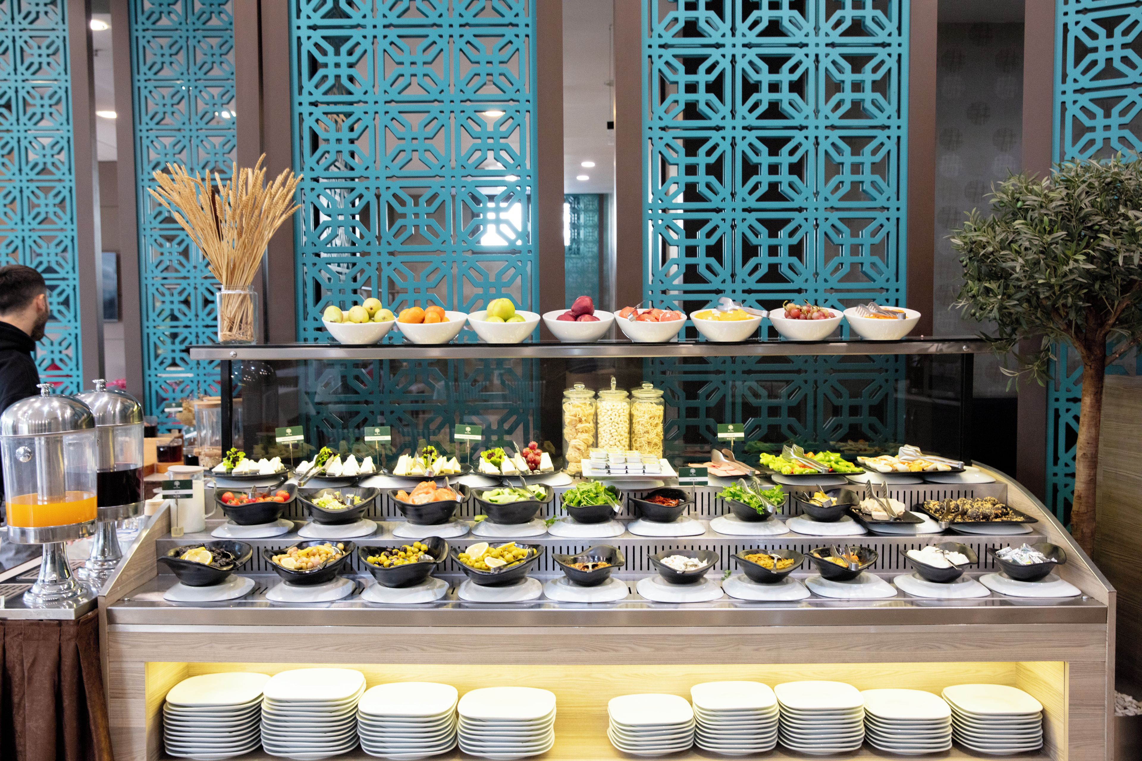 A buffet with various food options and a decorative blue partition.