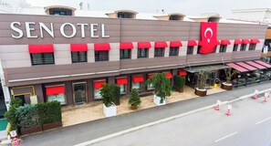 A hotel with a modern facade, red awnings, and a prominent flag. - Sakarya Sen Hotel (Serdivan)