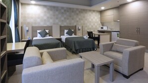 A hotel room with two beds, a desk, a chair, a small table, and a kitchenette. - Sakarya Sen Hotel (Serdivan)