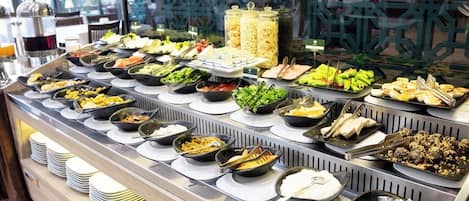 A buffet with various food items and condiments.