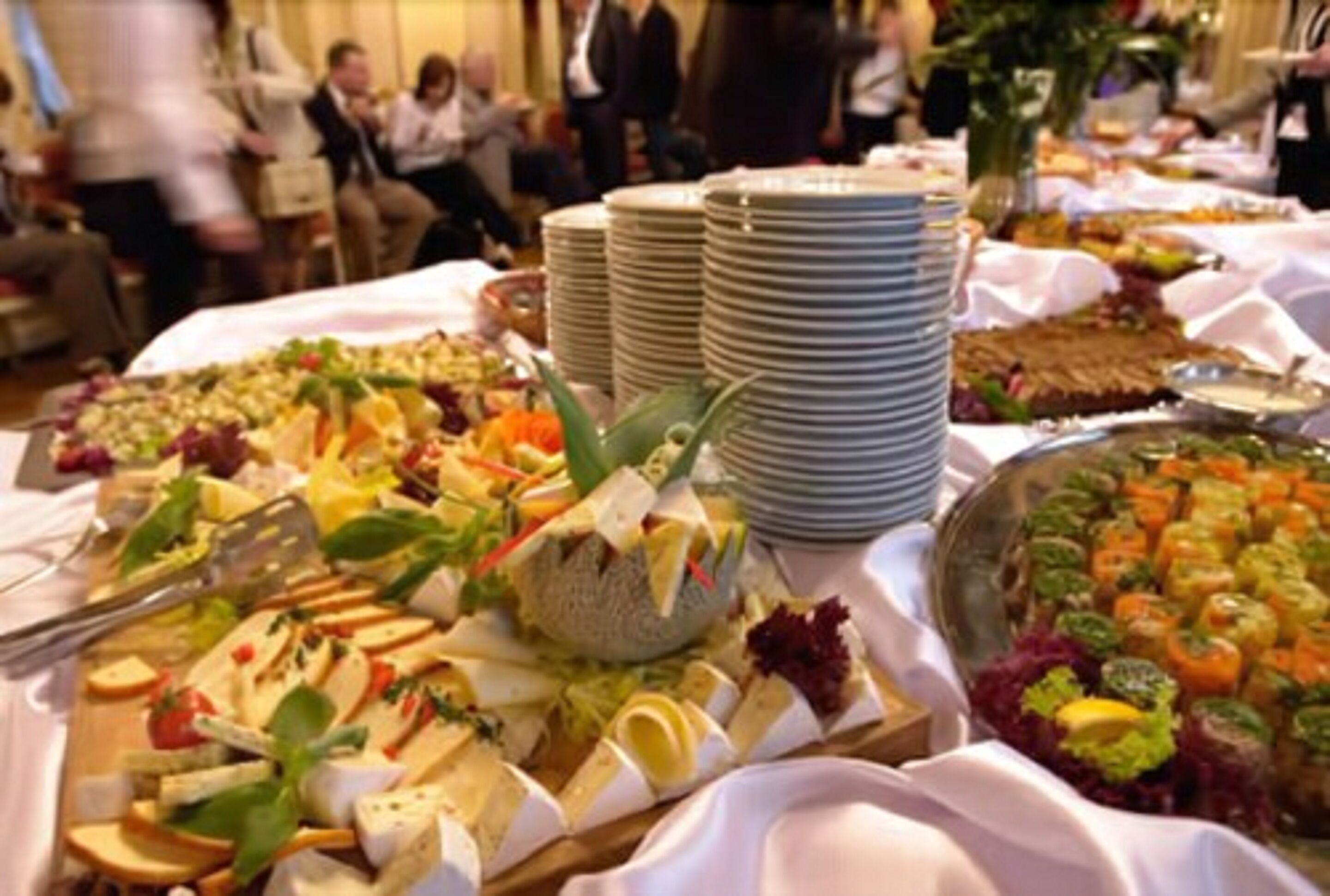 A buffet with various dishes and plates.