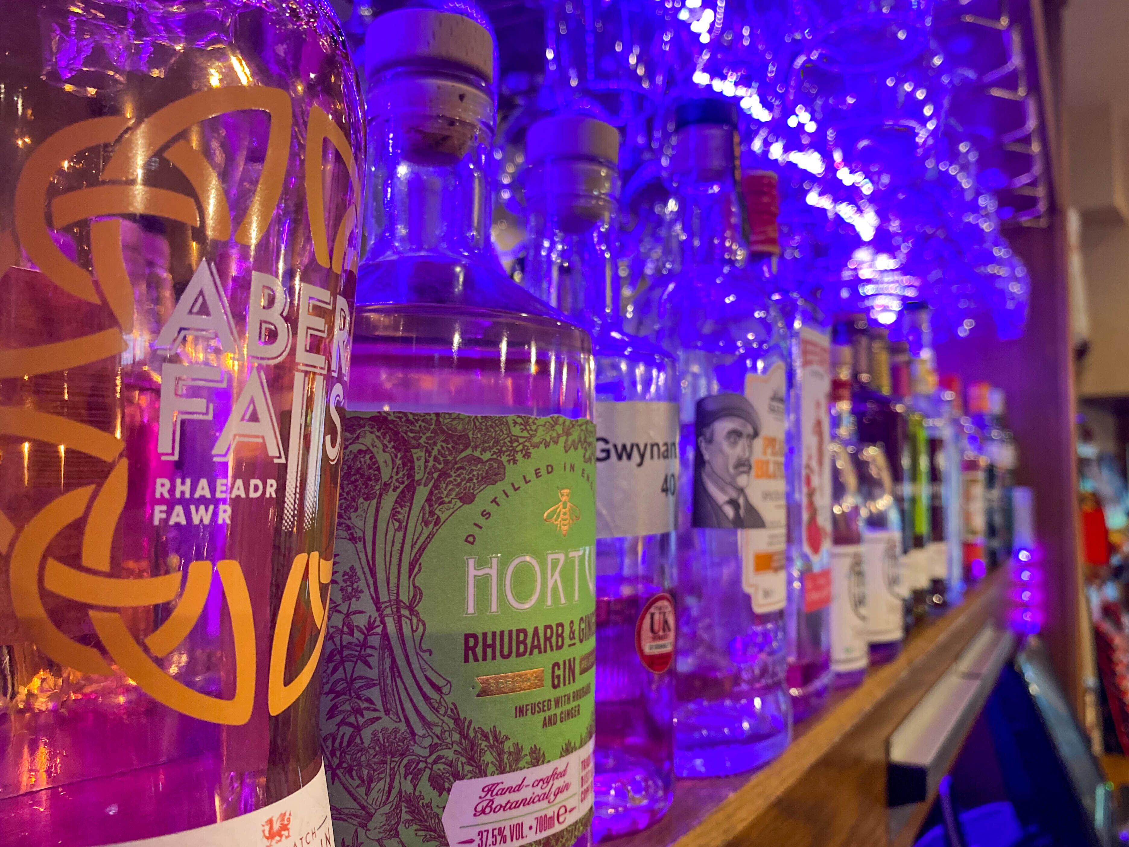 Un bar où l’on trouve diverses bouteilles d’alcool, dont une bouteille bien en évidence portant l’étiquette « Horty ».