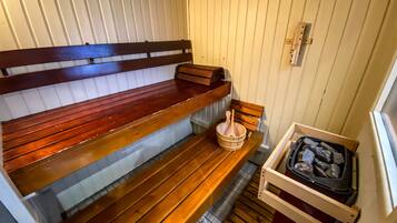 Una sauna con panche in legno e una vasca in pietra.