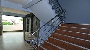 A modern staircase with metal railings and wooden steps, leading to an upper floor. - Kwanchanok Ville (Hua Hin)