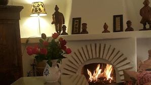 Un soggiorno accogliente con camino, un vaso di rose e un neonato su un divano.