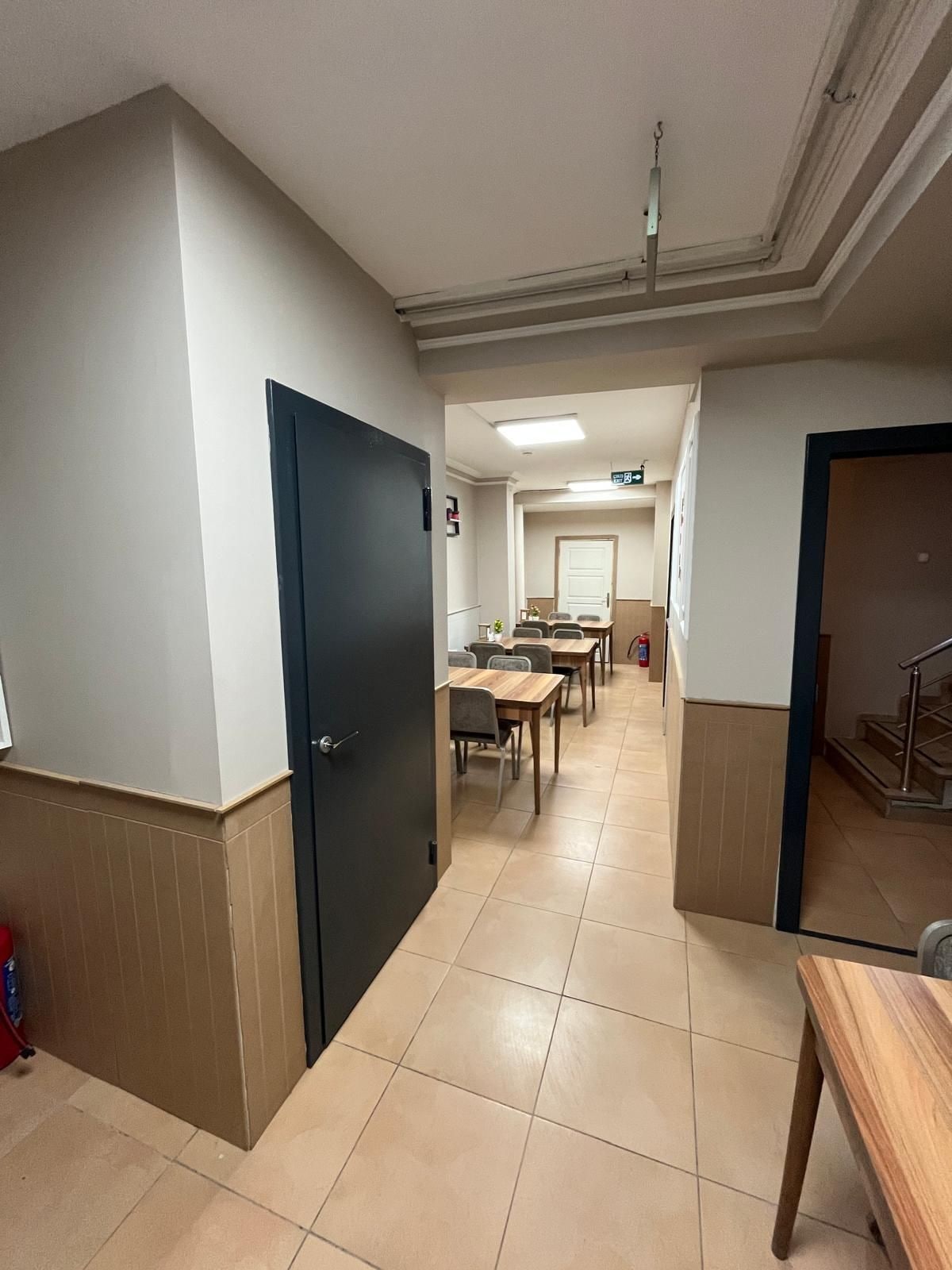Un pasillo de hotel con una zona de comedor, una escalera y una puerta.
