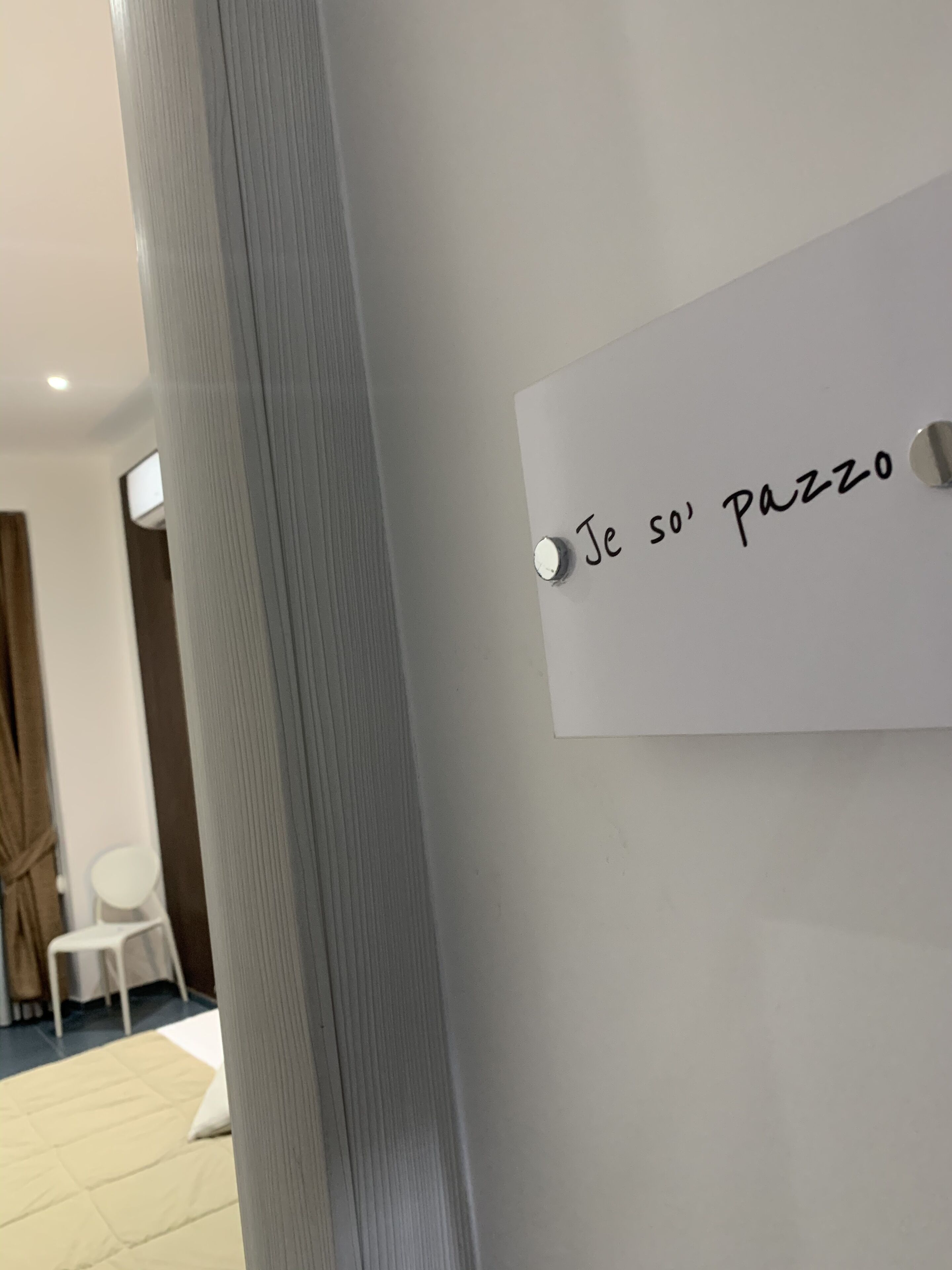 Una pizarra con el texto escrito a mano 'Je so' pazzo' en una pared.