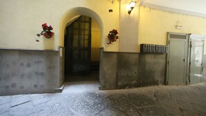 Un arco de entrada a una habitación con suelo de baldosas, un armario metálico y plantas en macetas.