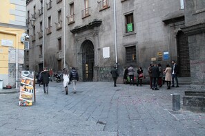 A historic building with a stone facade, large arched entrance, and multiple windows. - Mascalzone Latino Luxury Rooms (Naples)