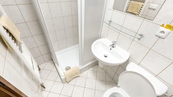 A modern bathroom with a shower, sink, and toilet.