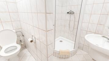 Un baño con inodoro, ducha y lavamanos.
