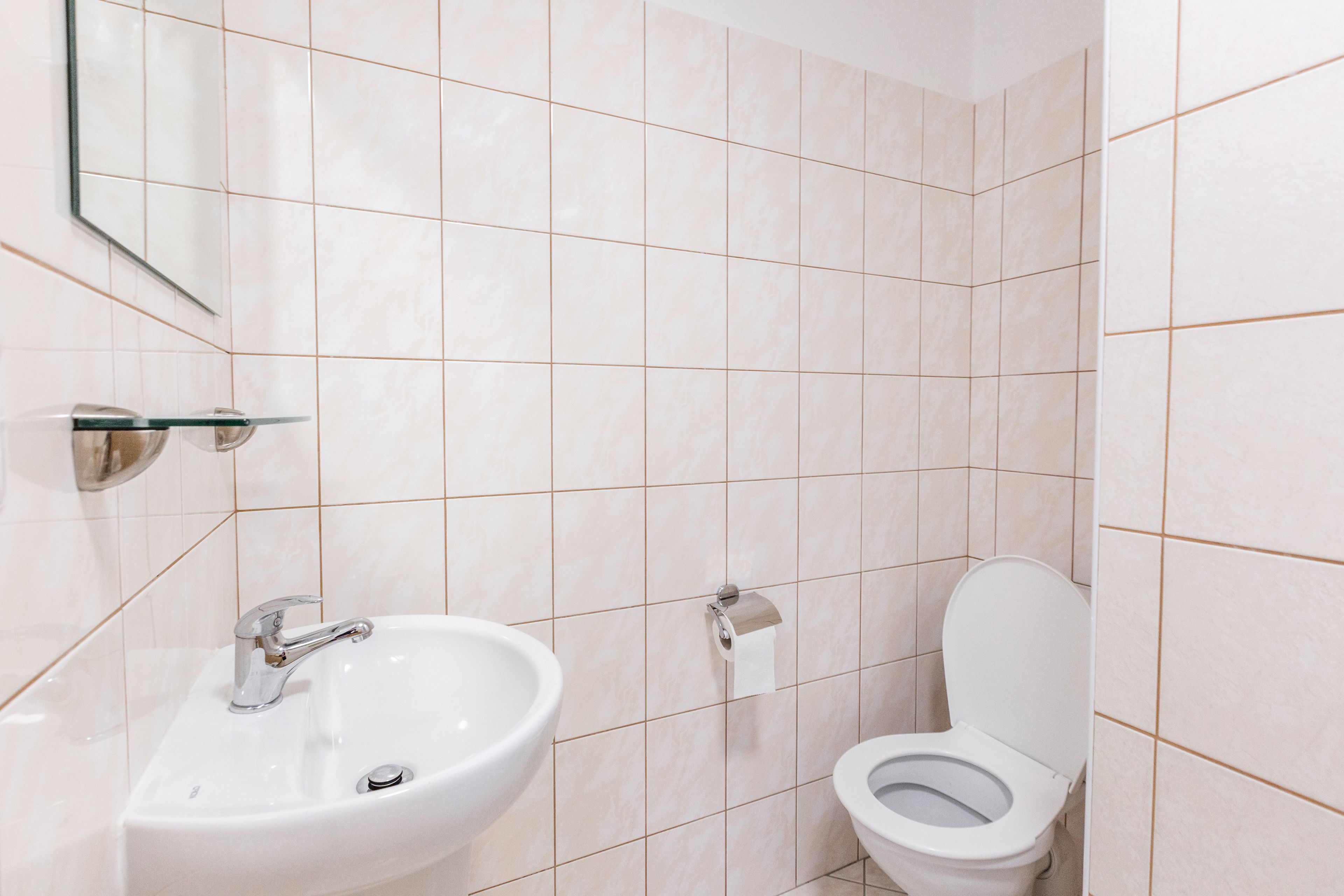 Ein Badezimmer mit Waschbecken, Toilette und Spiegel.