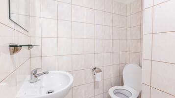 Ein Badezimmer mit Waschbecken, Toilette und Spiegel.