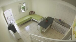 Una cocina compacta con una mesa de comedor, un banco y un lavamanos pequeño.