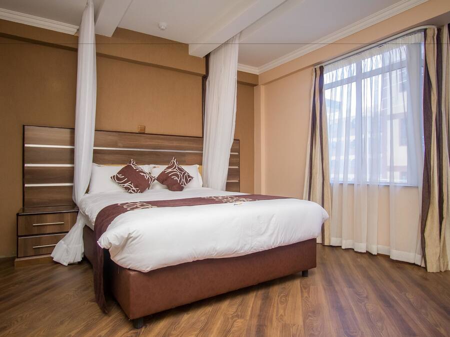 Un dormitorio con una cama grande, cabecera de madera y una mesita de noche.