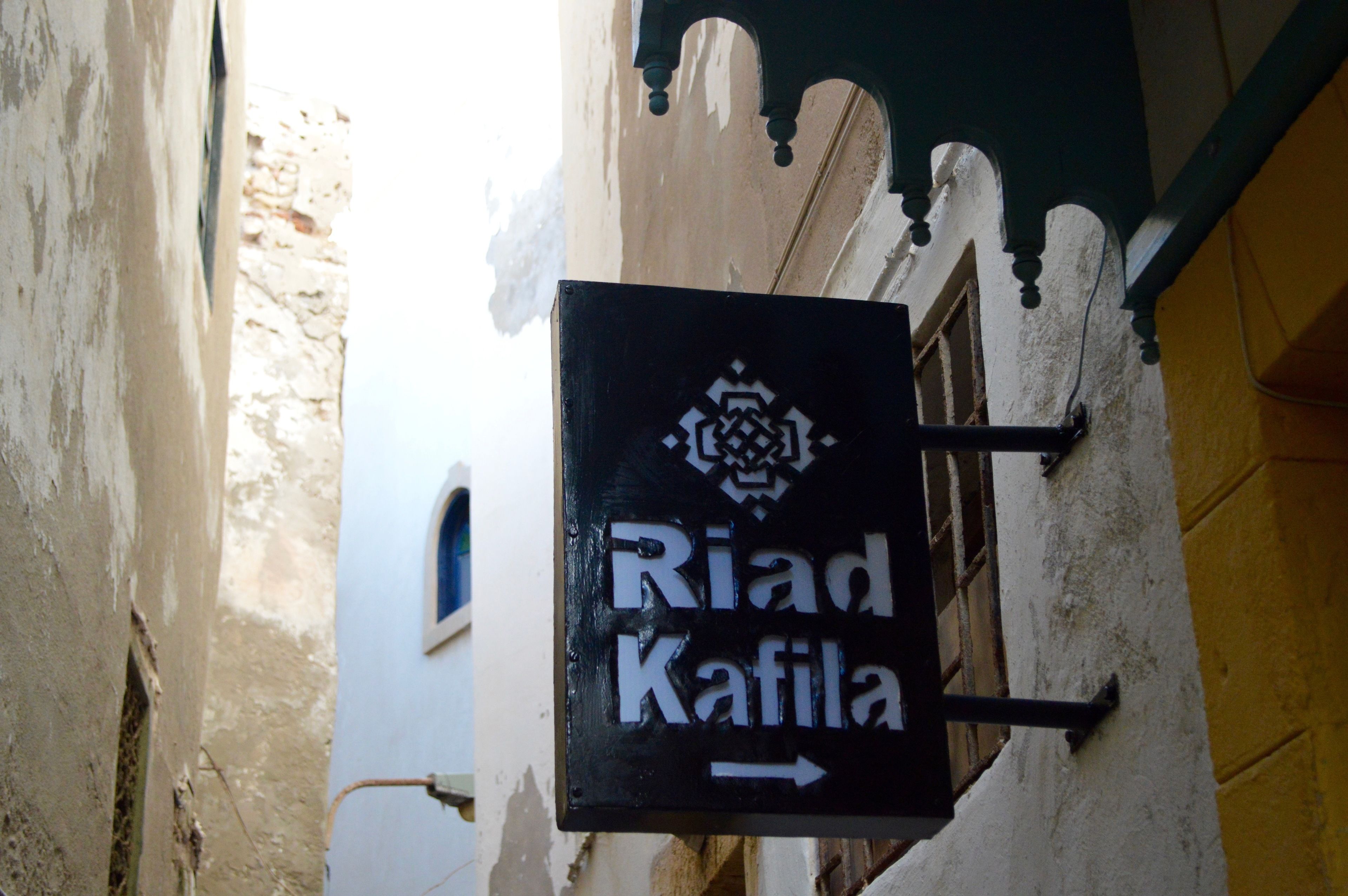 A sign for "Riad Kafilah" with a directional arrow.