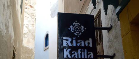 A sign for "Riad Kafilah" with a directional arrow.