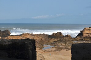 A rocky coastal landscape with waves crashing against the shore.