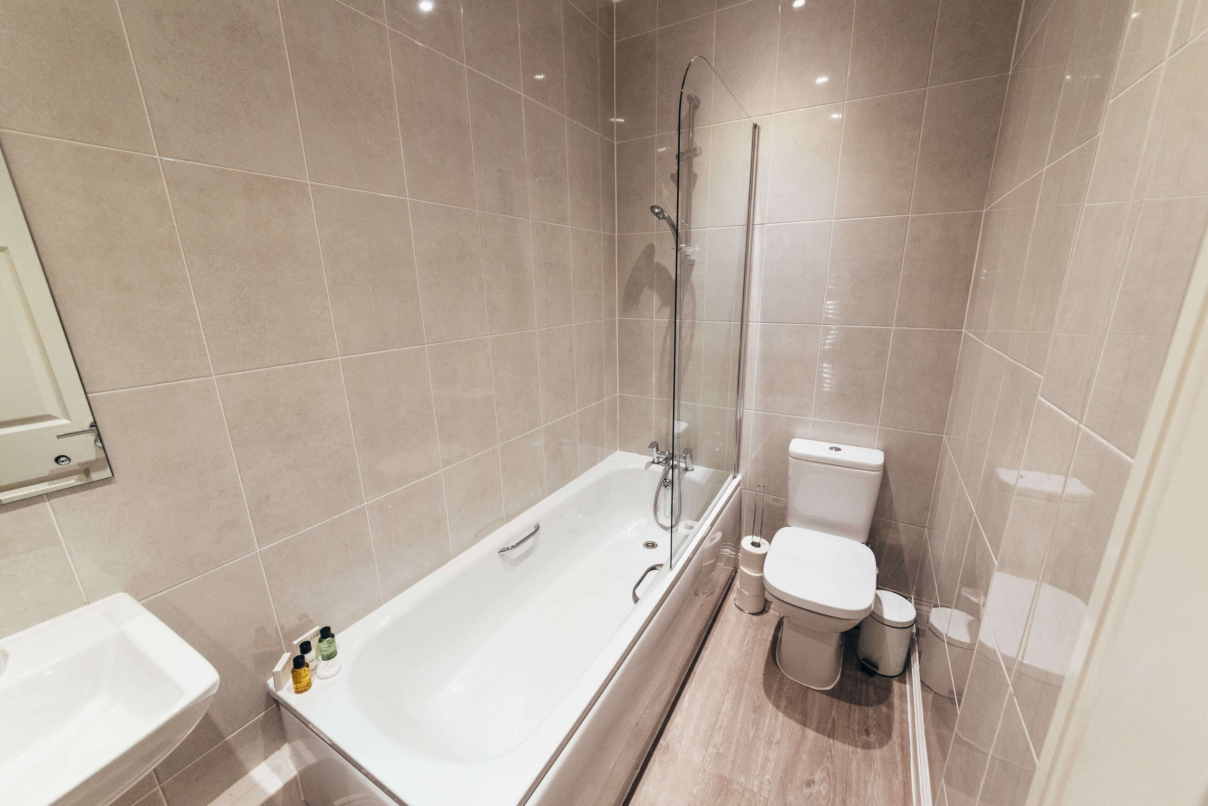 A modern bathroom with a bathtub, toilet, and sink.