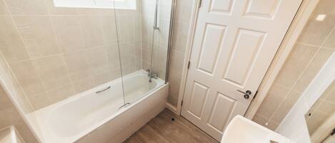 Une salle de bain avec une baignoire, une douche et un lavabo.