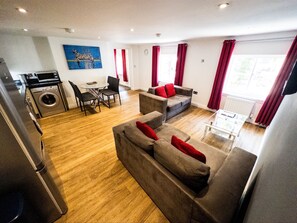 Apartamento Deluxe, 2 habitaciones | Zona de estar | Una televisión de pantalla plana, películas de pago
