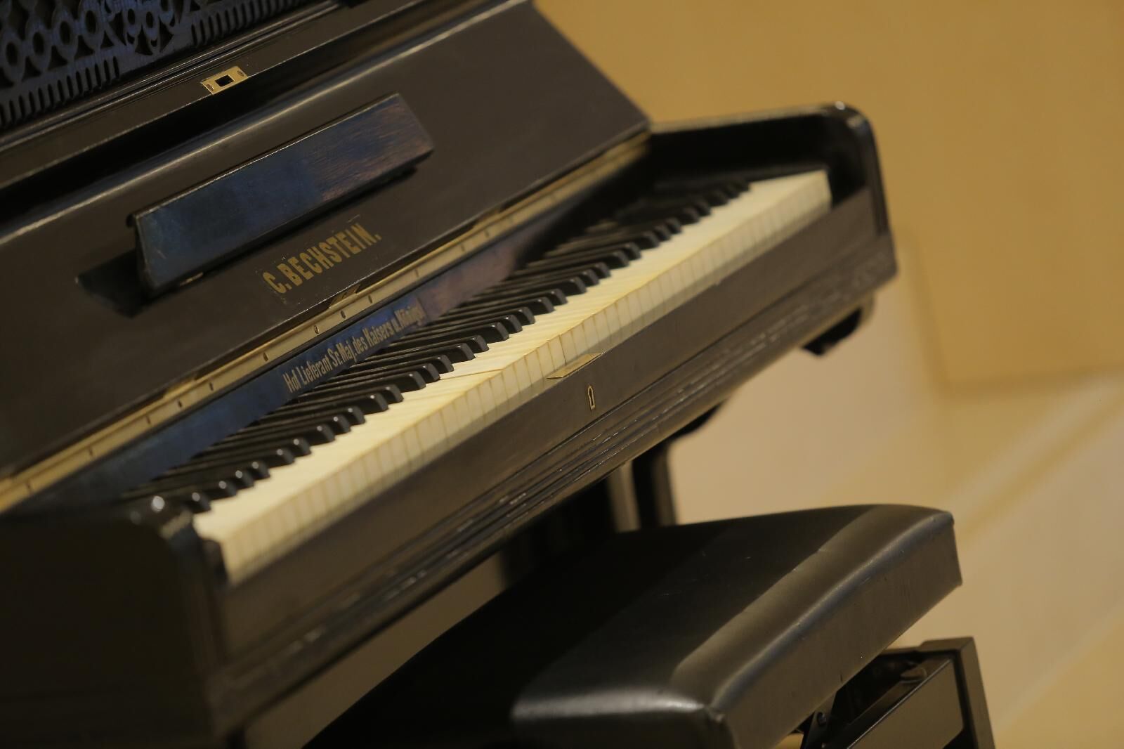 Un piano con exterior negro y una etiqueta que dice "BECHSTEIN".