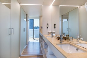 A modern bathroom with a long mirror, two sinks, and a glass shower enclosure. - Sea Porto Hotel (Matosinhos)