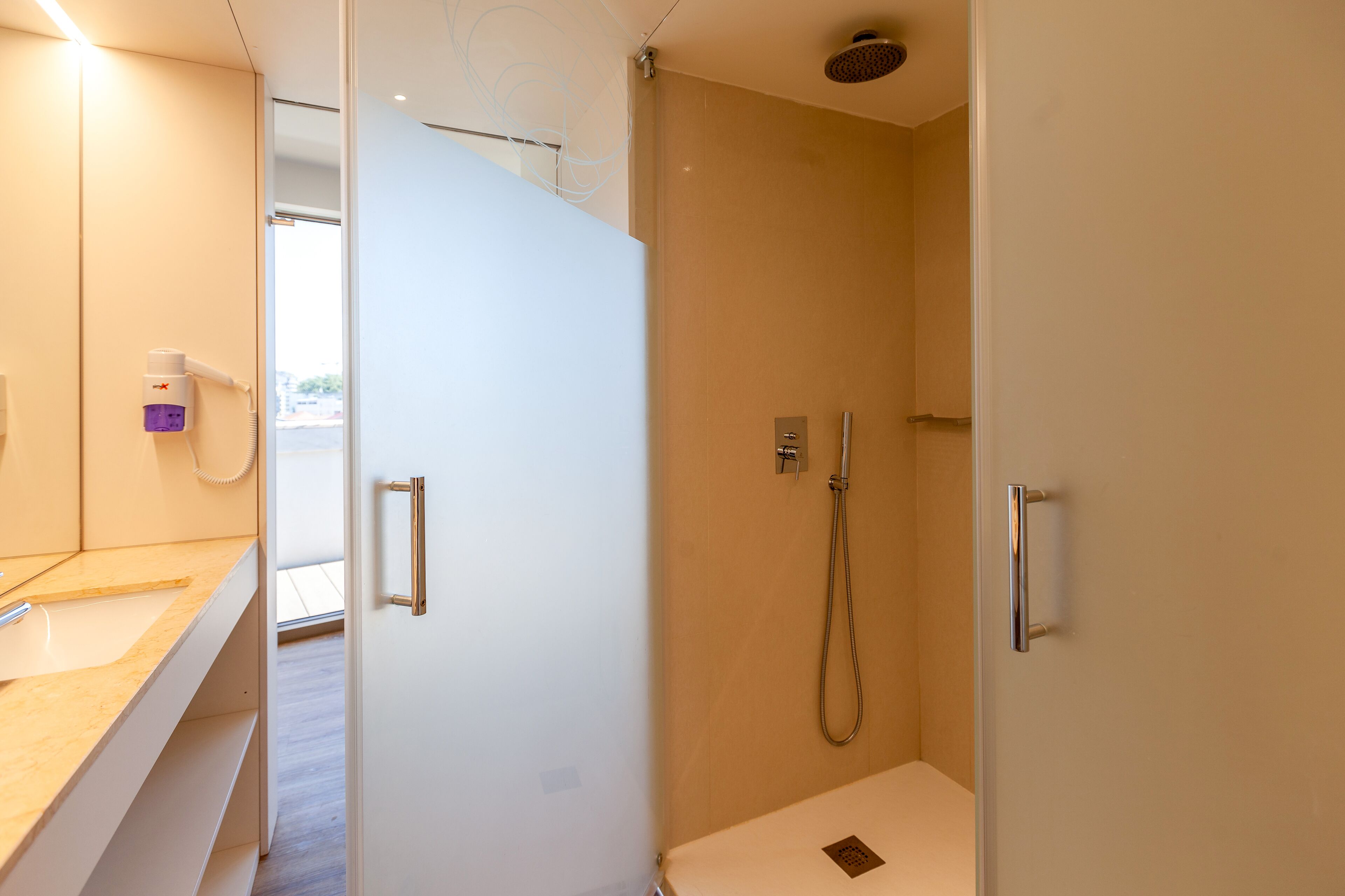 A modern bathroom with a shower, a vanity with a mirror, and a toilet.