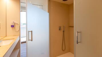 A modern bathroom with a shower, a vanity with a mirror, and a toilet.