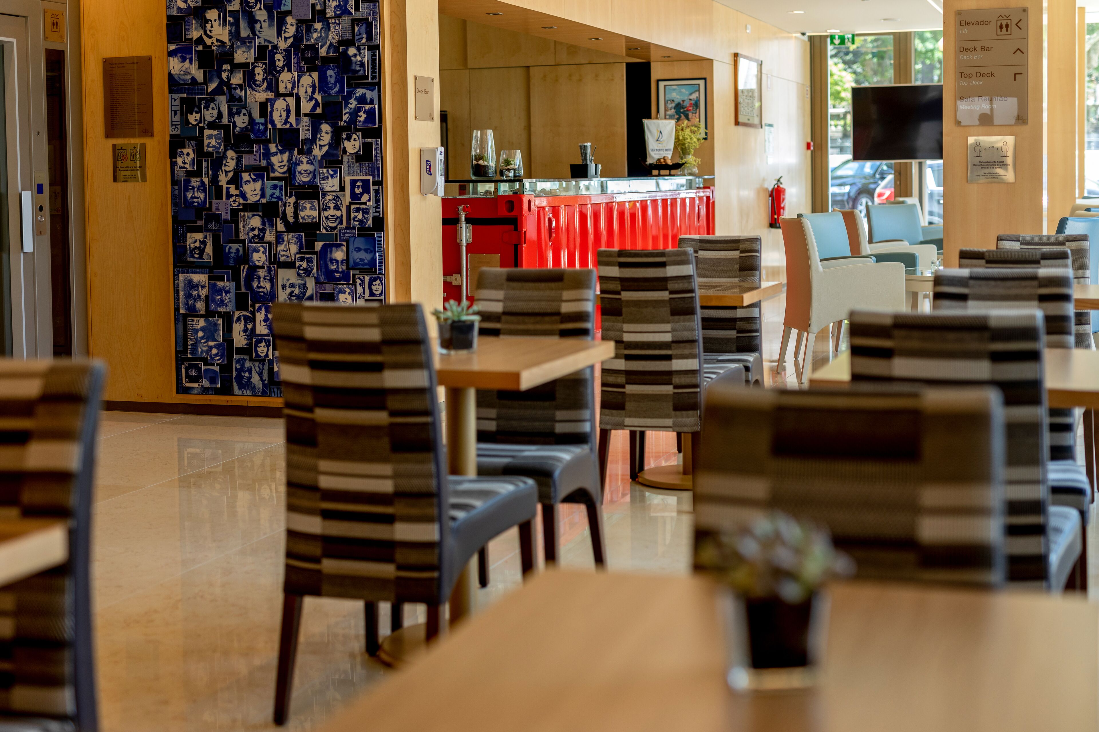 A restaurant with striped chairs, a red counter, and a wall of photos.