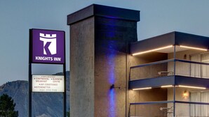 A Knights Inn sign with amenities listed, including continental breakfast, business center, air conditioning, kitchenettes, and kids stay free. - Knights Inn Lake City (Lake City)