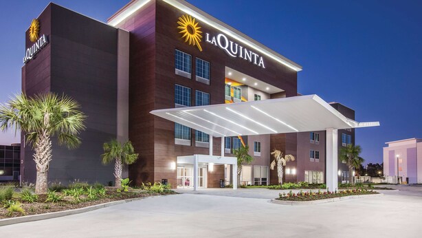 A La Quinta hotel with a modern design, featuring a prominent entrance and a covered outdoor area. - La Quinta Inn & Suites by Wyndham Baton Rouge - Port Allen (Port Allen)