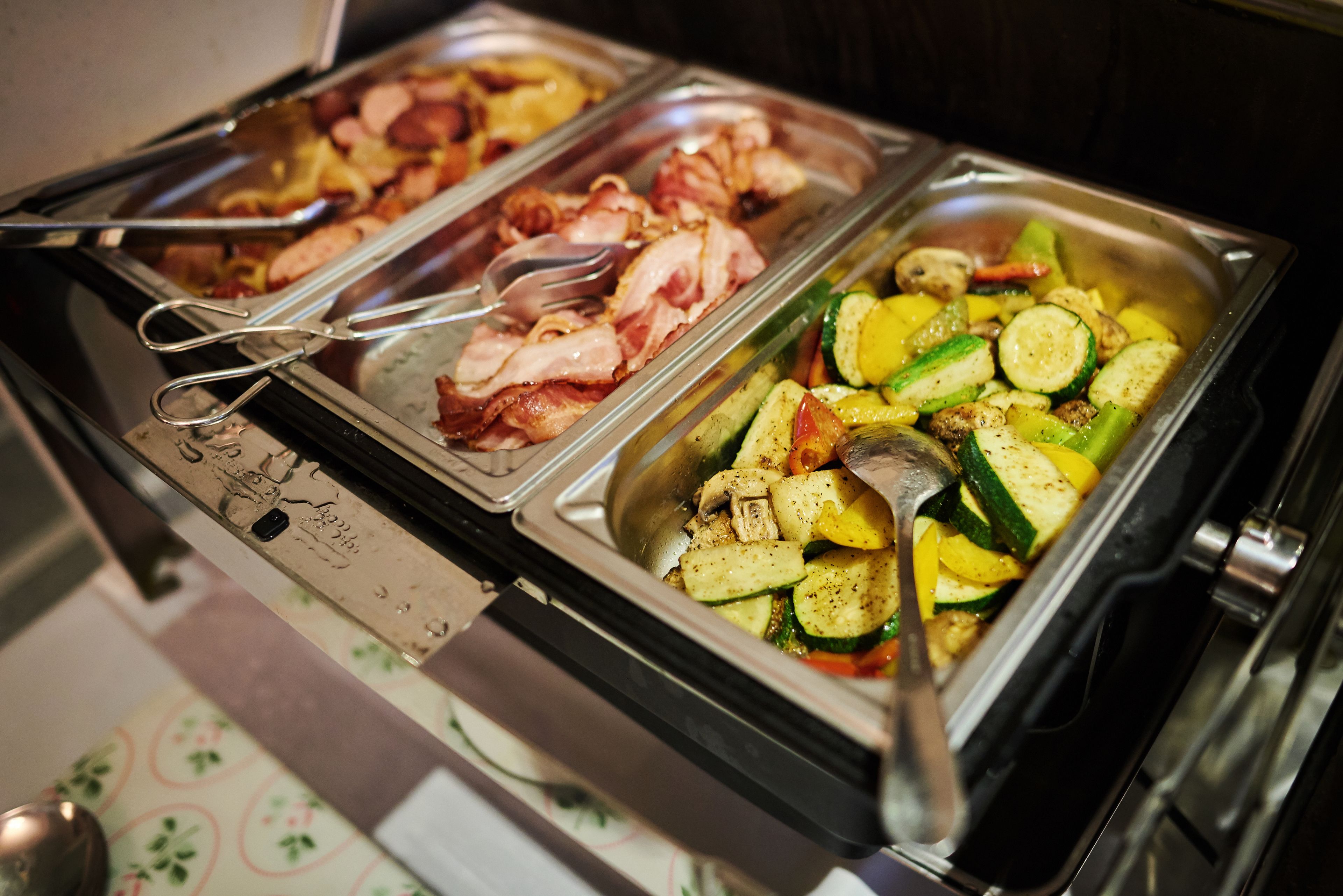 A buffet with various food options including meats and vegetables.