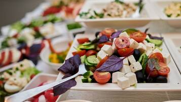 A variety of food platters with different salads and cheeses.