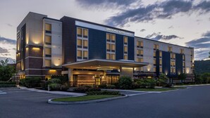 Un hotel moderno con techo plano, varias ventanas y una entrada bien iluminada.