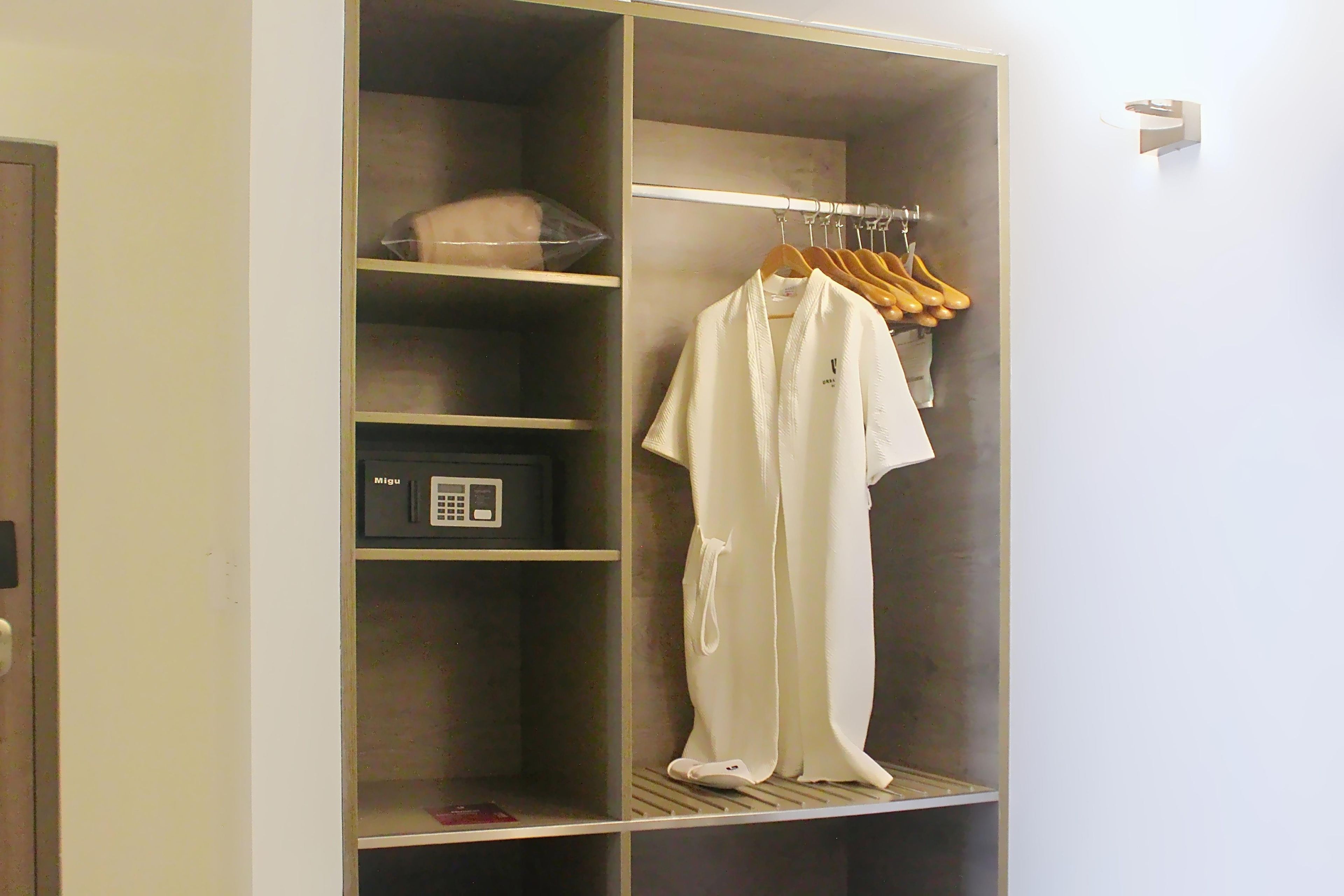 A walk-in closet with a hanging rack, shelves, and a storage unit.
