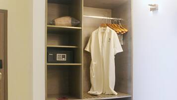 A walk-in closet with a hanging rack, shelves, and a storage unit.
