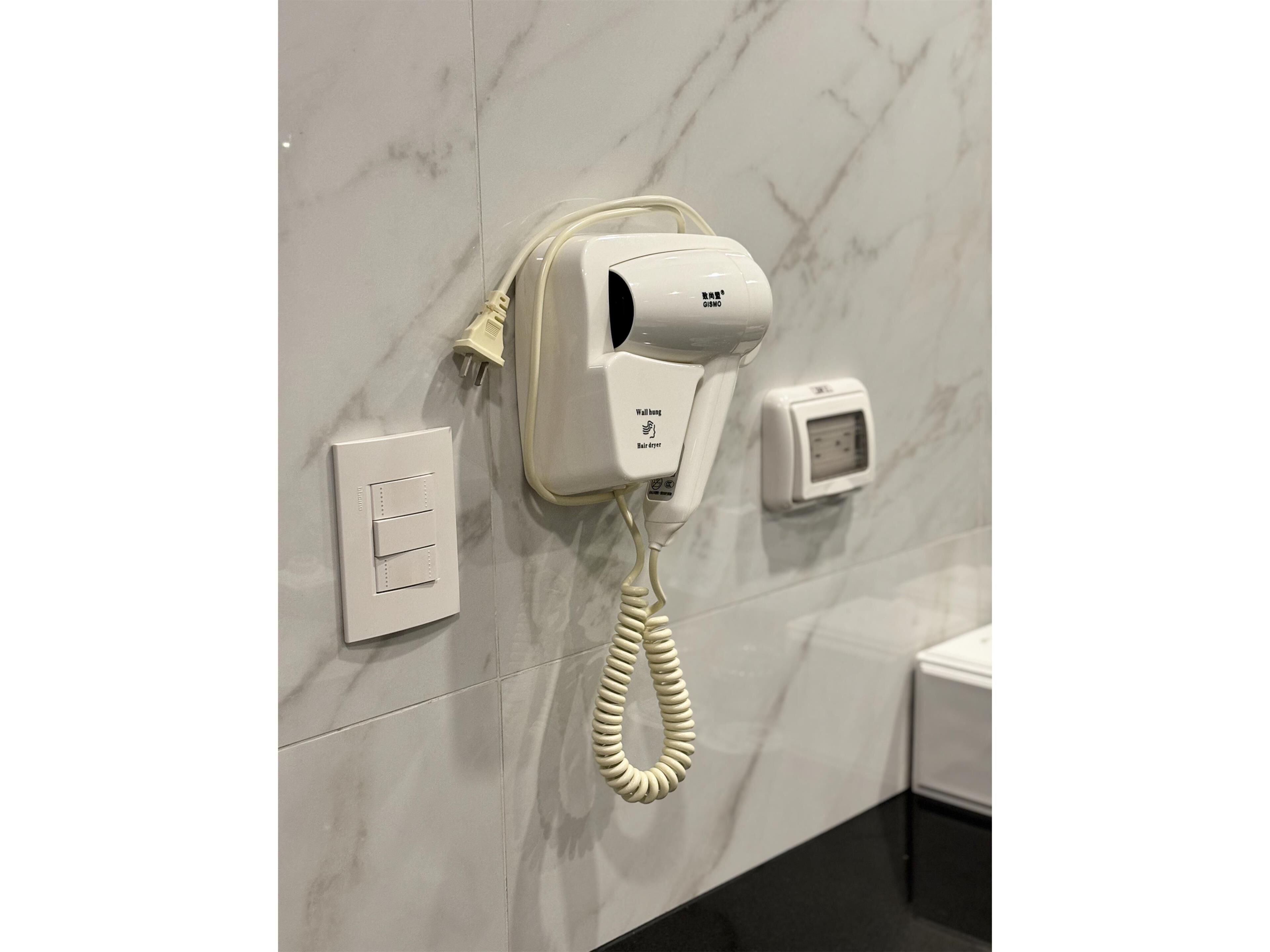 Secador de cabelo fixado na parede, com painel de controle e tomada.