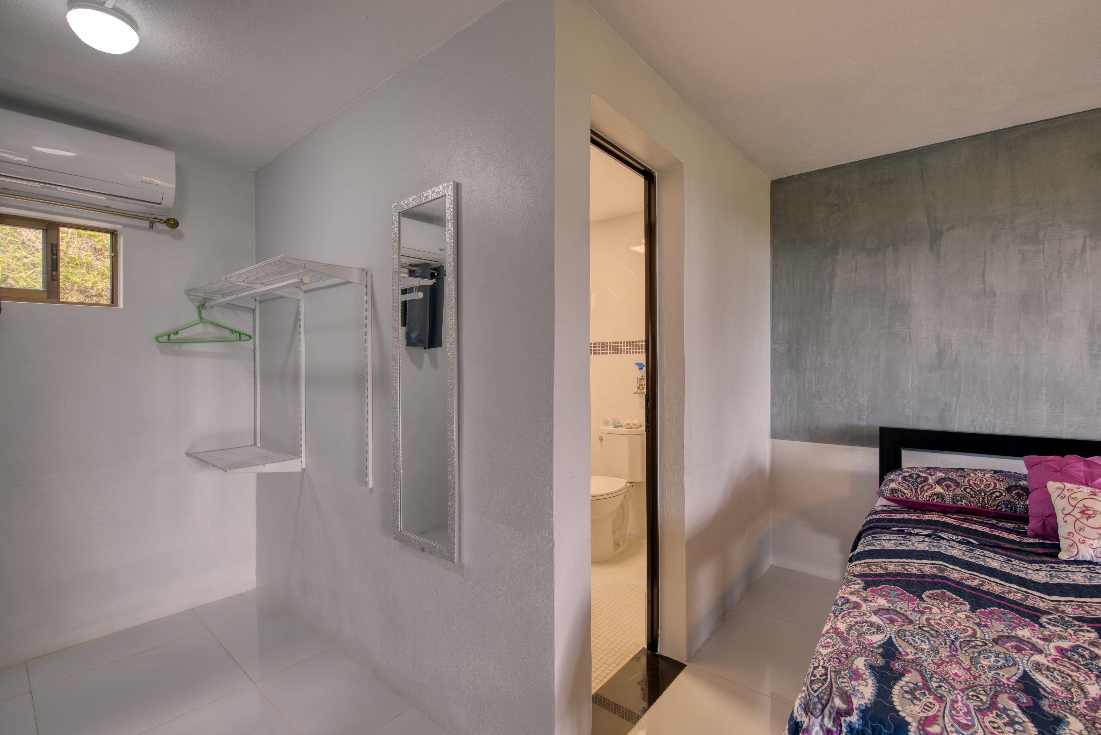 Un baño moderno con ducha, espejo y perchero.