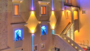 Un hotel con un letrero llamativo que dice "HOTEL CENACOLO" y una escalera que conduce a la entrada.