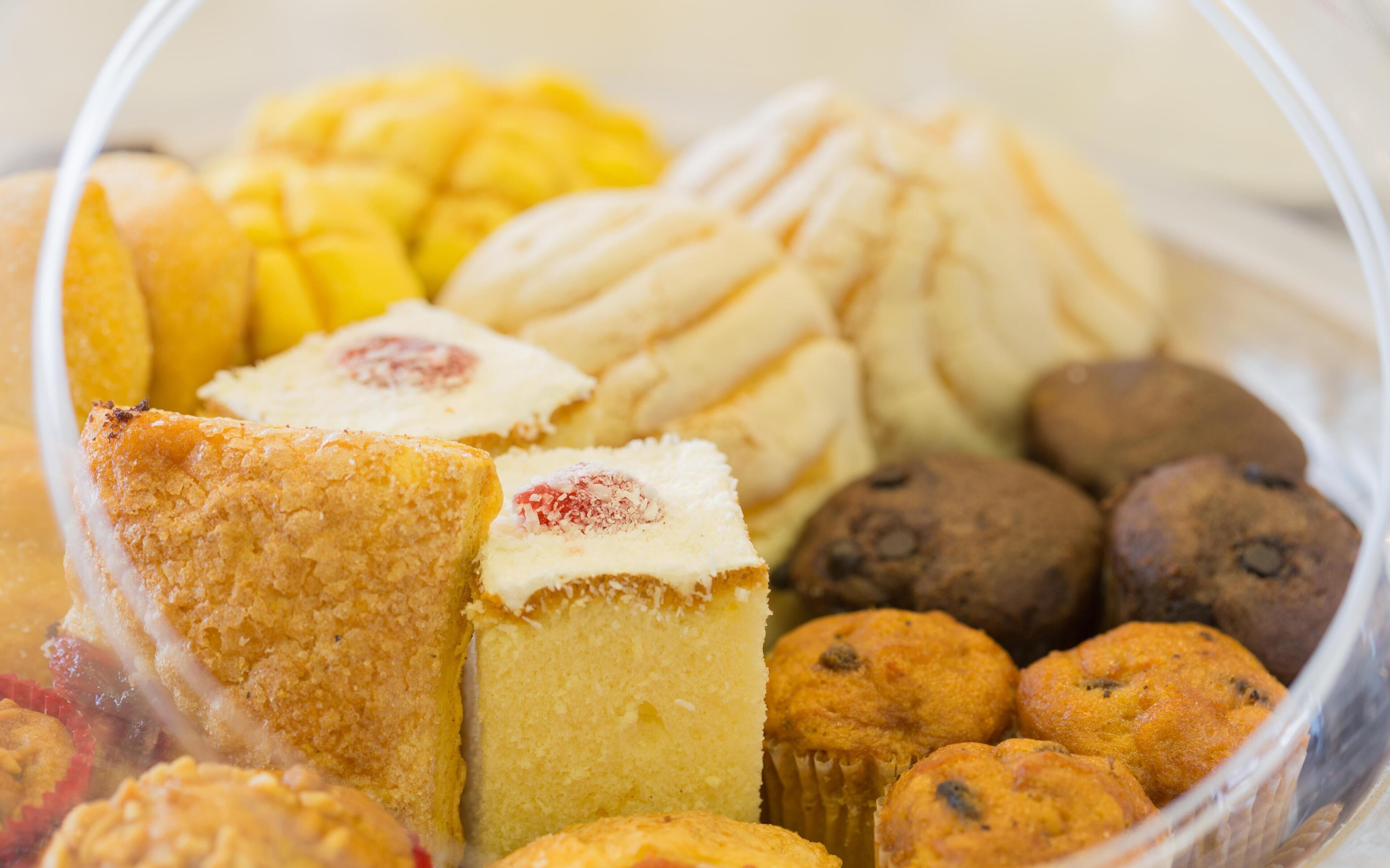 A variety of baked goods including muffins, cookies, and a cake.