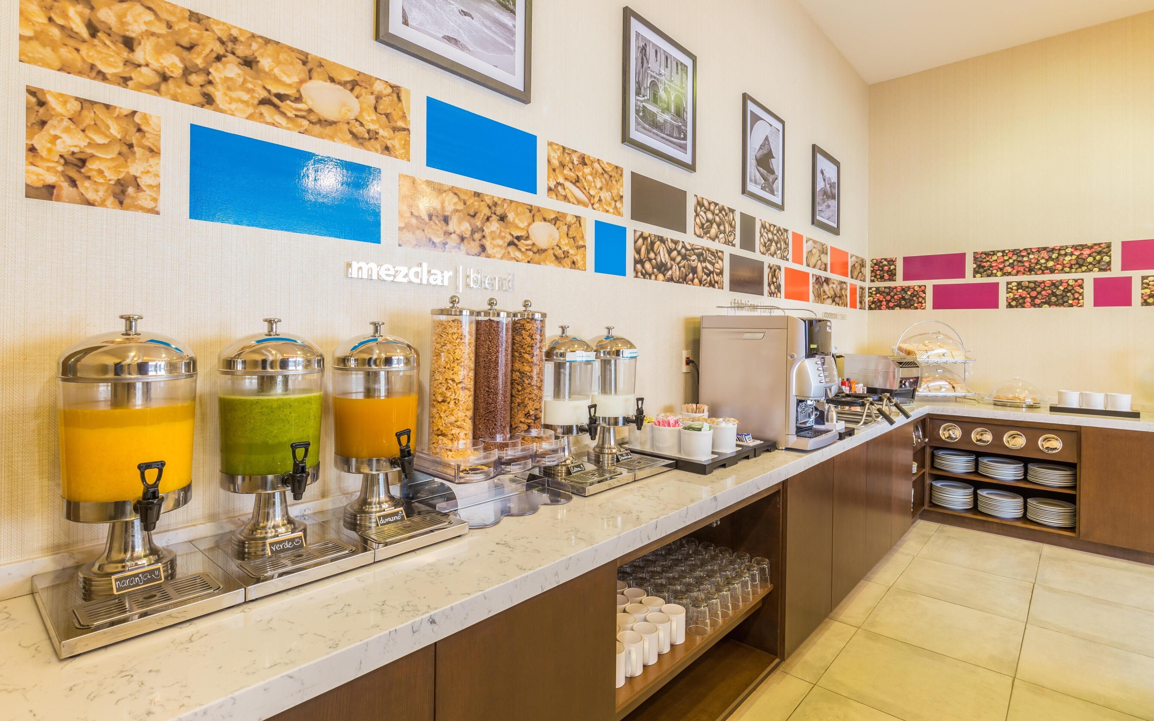 A breakfast bar with juice dispensers, a coffee machine, and a coffee station.
