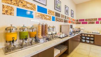 A breakfast bar with juice dispensers, a coffee machine, and a coffee station.