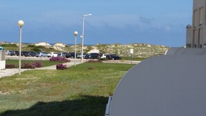 A parking lot with several cars and a building in the background. - Apartment sunny beach (Peniche)