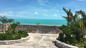 A stone wall with a view of the ocean. - Caribbean Sea Breeze Villas (Providenciales)
