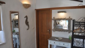 A bathroom with a wooden door, a mirror, a white desk, and a shelf with items. - Converted stables - double studio 8km Obidos with elevated deck & full kitchen (Obidos)