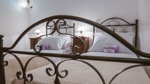 A bedroom with a bed, two bedside tables, and two wall-mounted lamps. - Trullo la Chianca Homerelax (Locorotondo)
